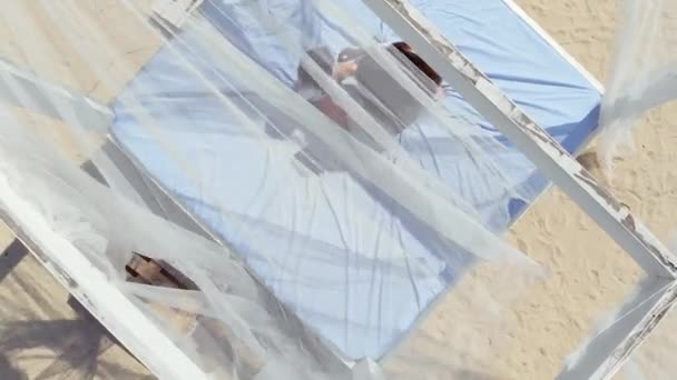 Squisita ragazza con la sua piccola figlia rilassarsi e giocare in bungalow sulla spiaggia . — Video Stock