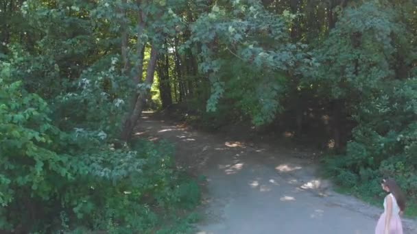 Elegantes Mädchen mit ihrer kleinen Tochter, die im Wald zwischen den Bäumen spazieren geht und Spaß hat. — Stockvideo