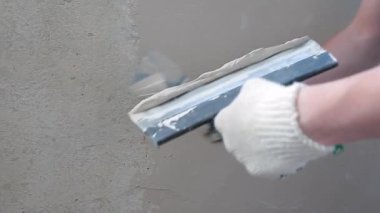 Usta spatulaya macun sürüyor. Balkonun, dairenin, evin yenilenmesi.