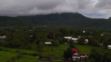 Aerial drone view over tropical volcanic camiguin island, Philippines, rugged mountain ranges, verdant green rainforests and clear blue seas, travel and tourism vacation holiday