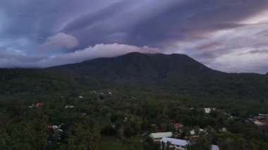 Aerial drone view over tropical volcanic camiguin island, Philippines, rugged mountain ranges, verdant green rainforests and clear blue seas, travel and tourism vacation holiday