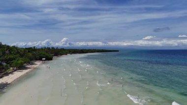 Dumaluan plajı, Filipinler, Bohol, tropikal palmiye ağaçları kıyıları ve Bangka tekneleri kenetlenmiş kristal berrak su üzerindeki hava aracı görüntüsü ve deniz çayırları mavi gökyüzü tatil gezisi için seyahat ediyor. 