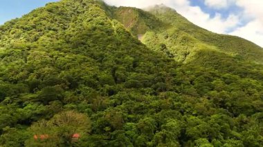 Yeşillik yeşil orman örtüleri ve kasvetli bulutlarla volkanik dağ sıraları ve buğulu Hibok Hibok Ulusal Parkı Filipinleri, Camiguin Adası Asya turizm beldesi Sinematik 