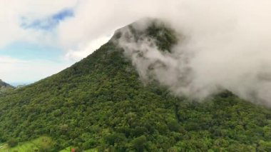 Yeşillik yeşil orman örtüleri ve kasvetli bulutlarla volkanik dağ sıraları ve buğulu Hibok Hibok Ulusal Parkı Filipinleri, Camiguin Adası Asya turizm beldesi Sinematik 