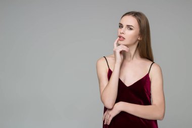 Uzun saçlı sarışın kız dard kırmızı elbise teşkil duygular gösterilen genç model