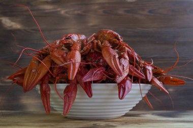 Pençeli ahşap arka plan üzerinde kırmızı haşlanmış crayfishes tabak