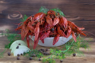 Pençeleri ve rezene, soğan ve biber ahşap arka plan üzerinde kırmızı haşlanmış crayfishes tabak