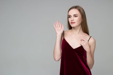 Duygular gösterilen koyu kırmızı elbiseli Genç modeli uzun saçlı sarışın kız poz portresi