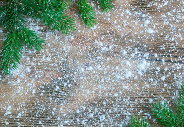 Green Christmas tree branches on winter snowbound wooden space b — Stock Photo, Image