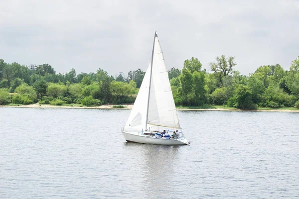 Sailboat yacht team sailing with full sails throught the wind on lake