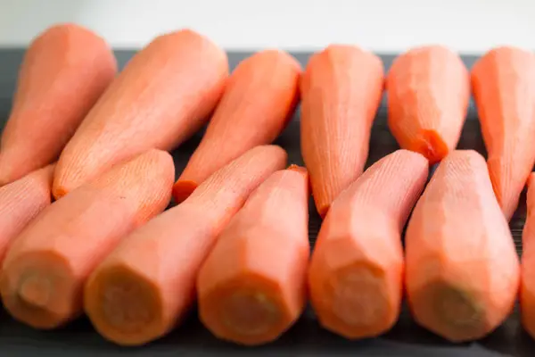 Очищенные желто-оранжево-красные овощи моркови, приготовленные к употреблению — стоковое фото