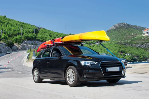 Turístico Coche Negro Viaja Transportando Canoa Amarilla Roo Imágenes de stock libres de derechos