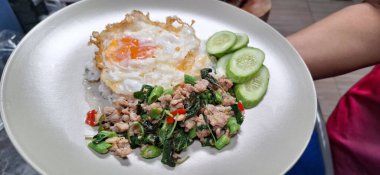 Kızarmış kıymalı pilav ve fesleğenli sahanda yumurta. Meşhur geleneksel Tayland yemeği. Yasemin pilavı ve sahanda yumurta ile servis ediliyor.