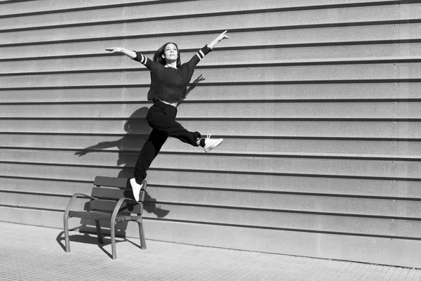 Black and white snapshot freezing the movement of a contemporary dance dancer in an urban setting