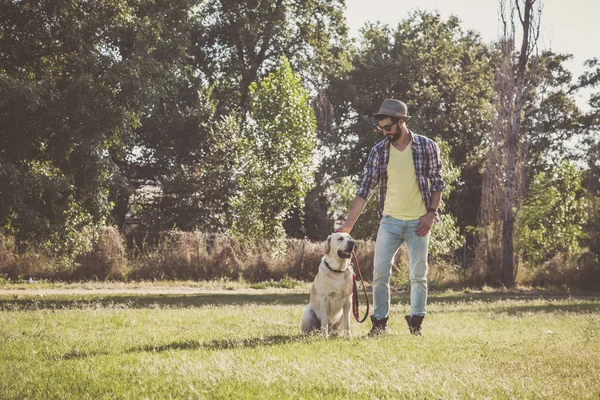 Young man posing with his canadian labrador dog in an urban park