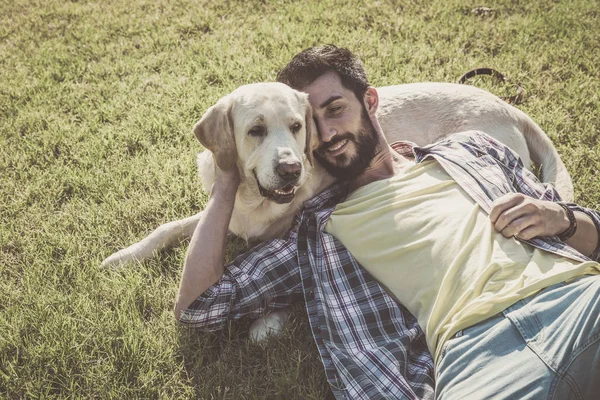 Canadian labrador dog resting in the park with his owner on a sunny day