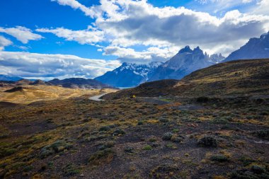 Şili 'deki Torres del Paine Ulusal Parkı' ndaki dağlara giden uzun ve güzel bir yol.