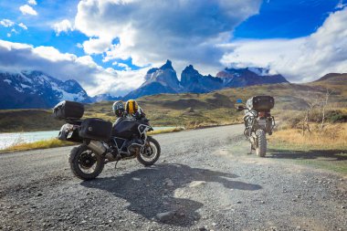 Şili 'deki Torres Del Paine Ulusal Parkı' ndaki dağlara giden uzun ve güzel yolda bir motorcu.