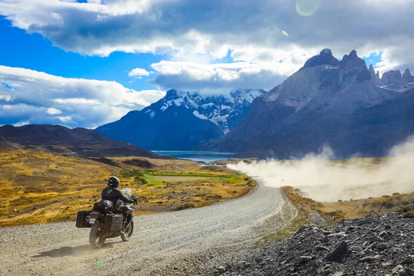 Şili 'deki Torres Del Paine Ulusal Parkı' ndaki dağlara giden uzun ve güzel yolda bir motorcu.