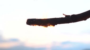 Gökyüzü arka plan karşı ahşap çubuk üzerinde küçük alev