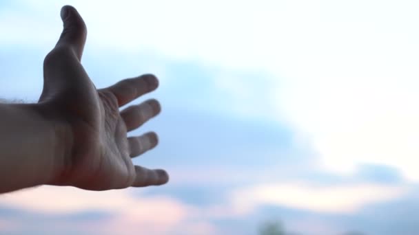 La mano toca el cielo, la mano masculina izquierda alcanza el cielo azul — Vídeos de Stock