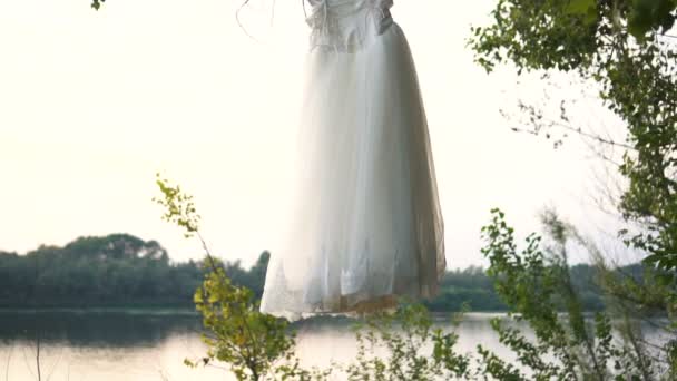 El vestido blanco de boda cuelga de un árbol — Vídeos de Stock