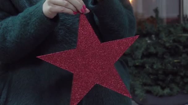 Main tenant ornement étoile rouge de Noël 