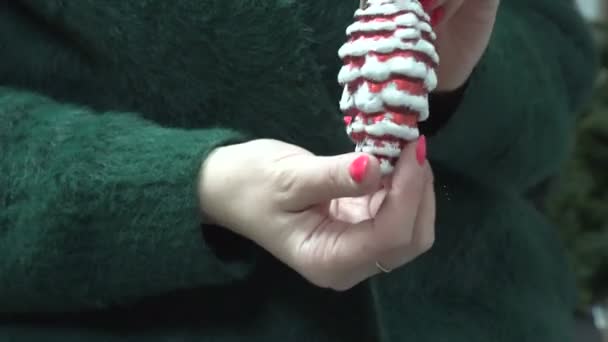 手にグッズの赤いコーンを保持している明るい温かみのあるグリーンのウール セーターの女 クリスマス 新年の休日の概念 — ストック動画
