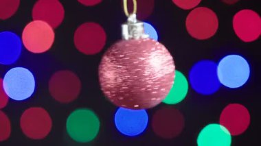 Christmas kırmızı top oyuncak yakın çekim dönüyor. Yeni yıl ağacı ışıkları arka plan üzerinde kırpma ile dekor