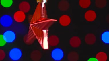 Christmas kırmızı yıldız oyuncak yakın çekim dönüyor. Yeni yıl ağacı ışıkları arka plan üzerinde kırpma ile dekor