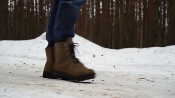 Walking feet in vilt laarzen op een winter landschap in slow motion, een winterwandeling in het bos — Stockvideo