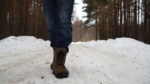 Κοντινό πλαίσιο των Man πόδια περπατώντας στο δρόμο στο χιόνι. — Αρχείο Βίντεο