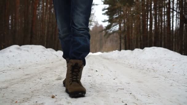 Gros plan de mans pieds marchant sur la route dans la neige . — Video