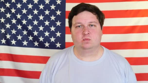 Portret grubego człowieka przed amerykańską flagą — Wideo stockowe