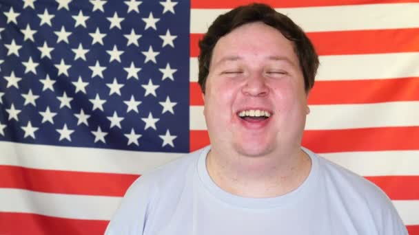 Young man laughing on the background of an USA flag — Stock Video