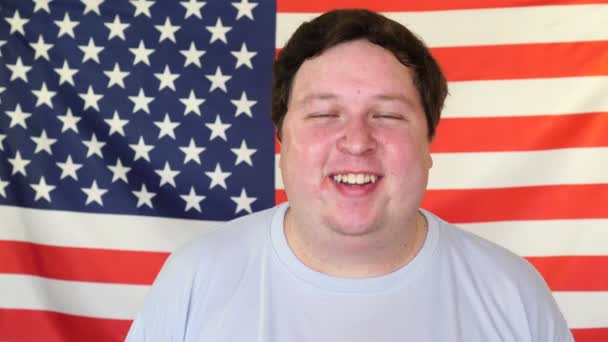 Dicker Mann lacht auf dem Hintergrund einer US-Flagge — Stockvideo