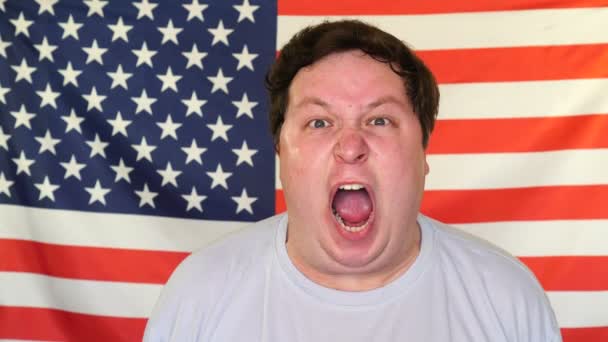 Dikke man schreeuwen op de achtergrond van een USA vlag — Stockvideo