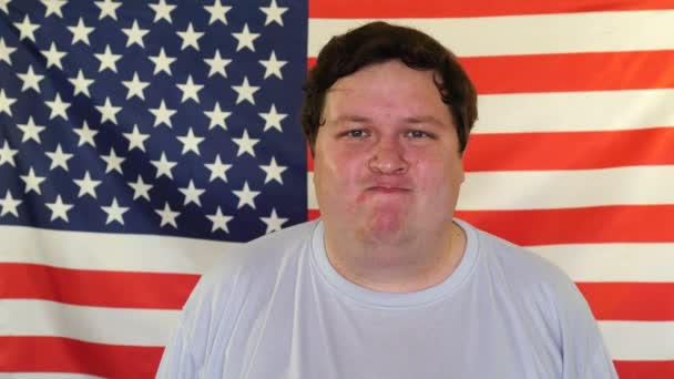 Portré a fiatal dühös ember a háttérben egy amerikai zászló — Stock videók