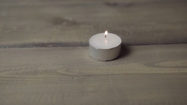Eine brennende Kerze auf einem Holztisch — Stockvideo