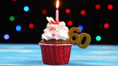 Yanan mum ve çok renkli bulanık ışıklar arka plan üzerinde sayı 60 ile Lezzetli doğum günü cupcake