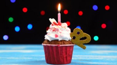 Yanan mum ve çok renkli bulanık ışıklar arka plan üzerinde sayı 82 ile Lezzetli doğum günü cupcake
