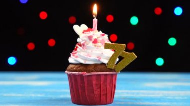 Yanan mum ve çok renkli bulanık ışıklar arka plan üzerinde numara 71 ile Lezzetli doğum günü cupcake