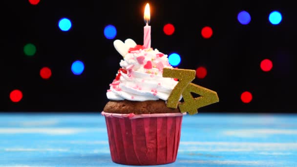 Νόστιμο κέικ γενεθλίων με κάψιμο κερί και αριθμός 74 σε πολύχρωμα θολά φώτα φόντο — Αρχείο Βίντεο
