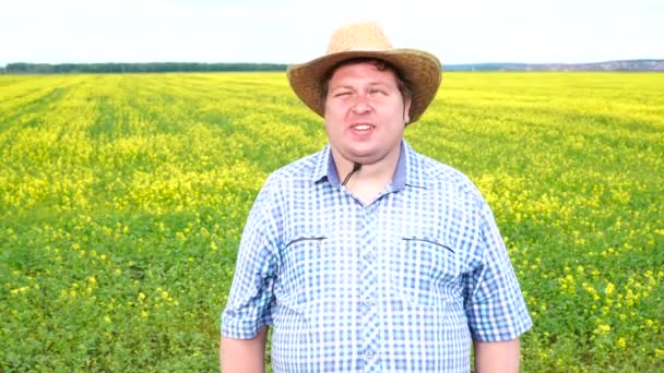 Портрет фермера, стоящего в поле, носит ковбойскую шляпу в солнечный день — стоковое видео