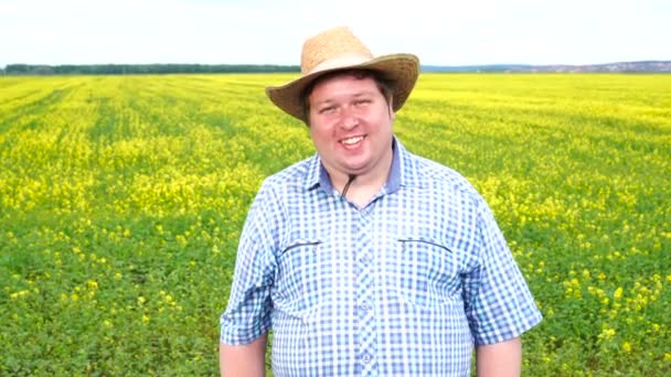 Портрет счастливого фермера, стоящего в поле в солнечный день — стоковое видео