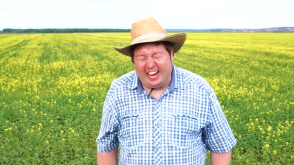 Porträt eines glücklichen Bauern, der an einem sonnigen Tag auf dem Feld steht und lacht — Stockvideo