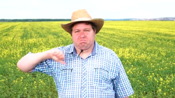 Portrait of farmer who showing thumb down in the field on a sunny day — Stock Video