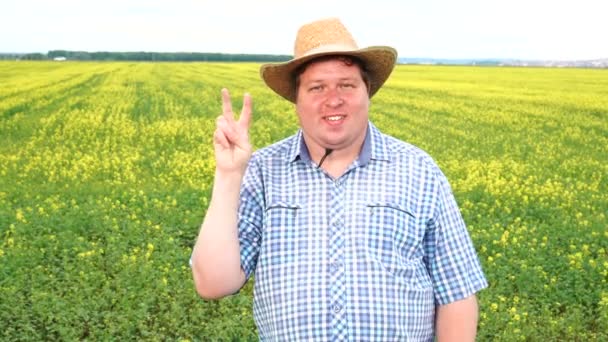 Farmer standing in field and showing sign of victory, wear cowboy hat on a sunny day — Stock Video