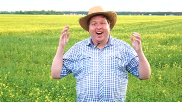 Überglücklich aufgeregt schockiert brünette junge Mann mit Cowboyhut Blick Kamera hebt die Hände auf dem Feld an sonnigen Tag. — Stockvideo