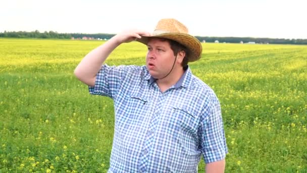 Retrato de un agricultor macho parado en un suelo agrícola fértil, mirando a la distancia — Vídeos de Stock